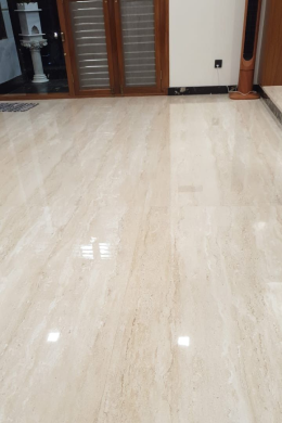 Shiny beige marble floor in a room with wooden doors and glass panels, reflecting ceiling light—an elegant touch for any interior design or home renovation project.